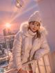 A woman in a white coat and hat posing for a picture.