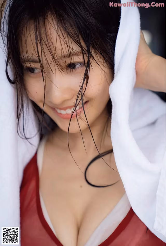 A woman in a red dress with a white towel over her head.