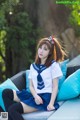 A woman in a sailor outfit sitting on a couch.