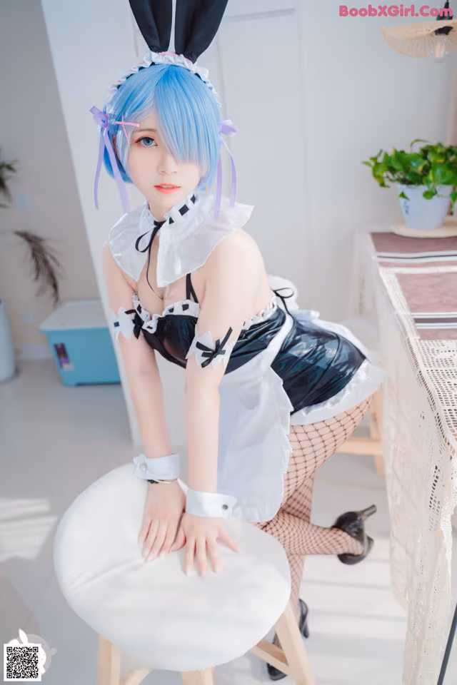 A woman in a bunny costume sitting on a stool.