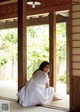 A woman in a white dress sitting on the floor.