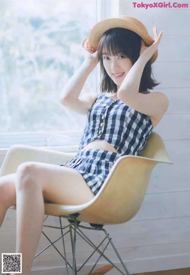 A woman sitting in a chair wearing a hat.