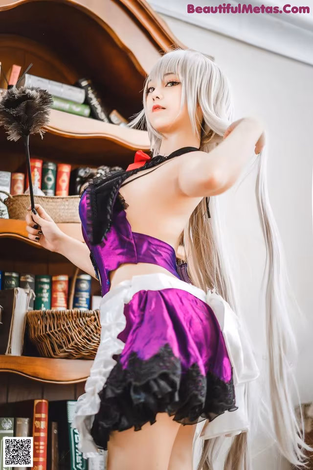 A woman in a maid outfit holding a broom.