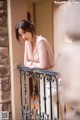 A woman leaning on a railing with her arms crossed.