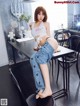 A woman sitting on top of a table in a kitchen.