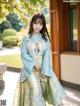 A woman in a blue and gold hanfu posing for a picture.