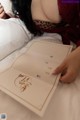 A woman laying on a bed holding a menu.