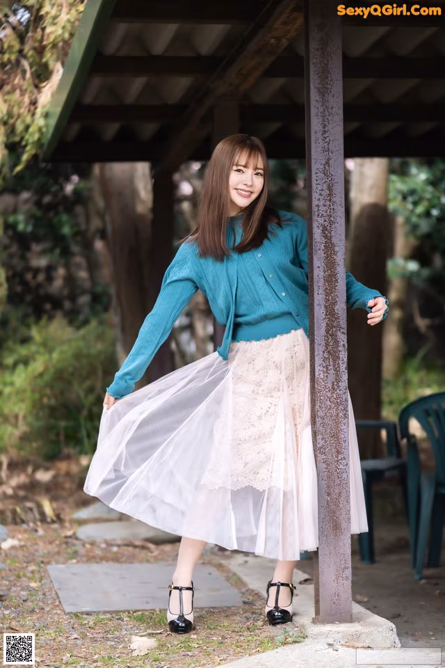 A woman in a blue sweater and a white tulle skirt.