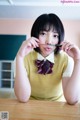 A woman sitting at a table with a pencil in her mouth.